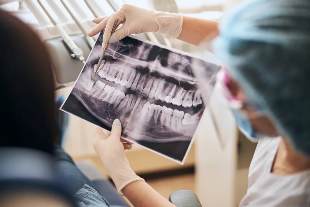 A dentist reviewing a panoramic dental x-ray