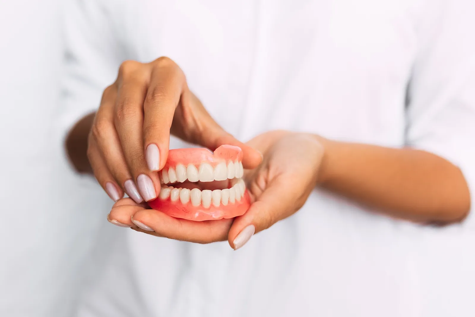 A full denture held in two hands